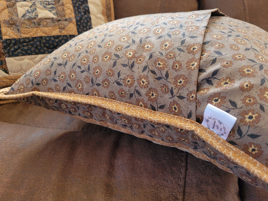 Showing overlapping back of pillow with handmade label, sitting on a sofa.