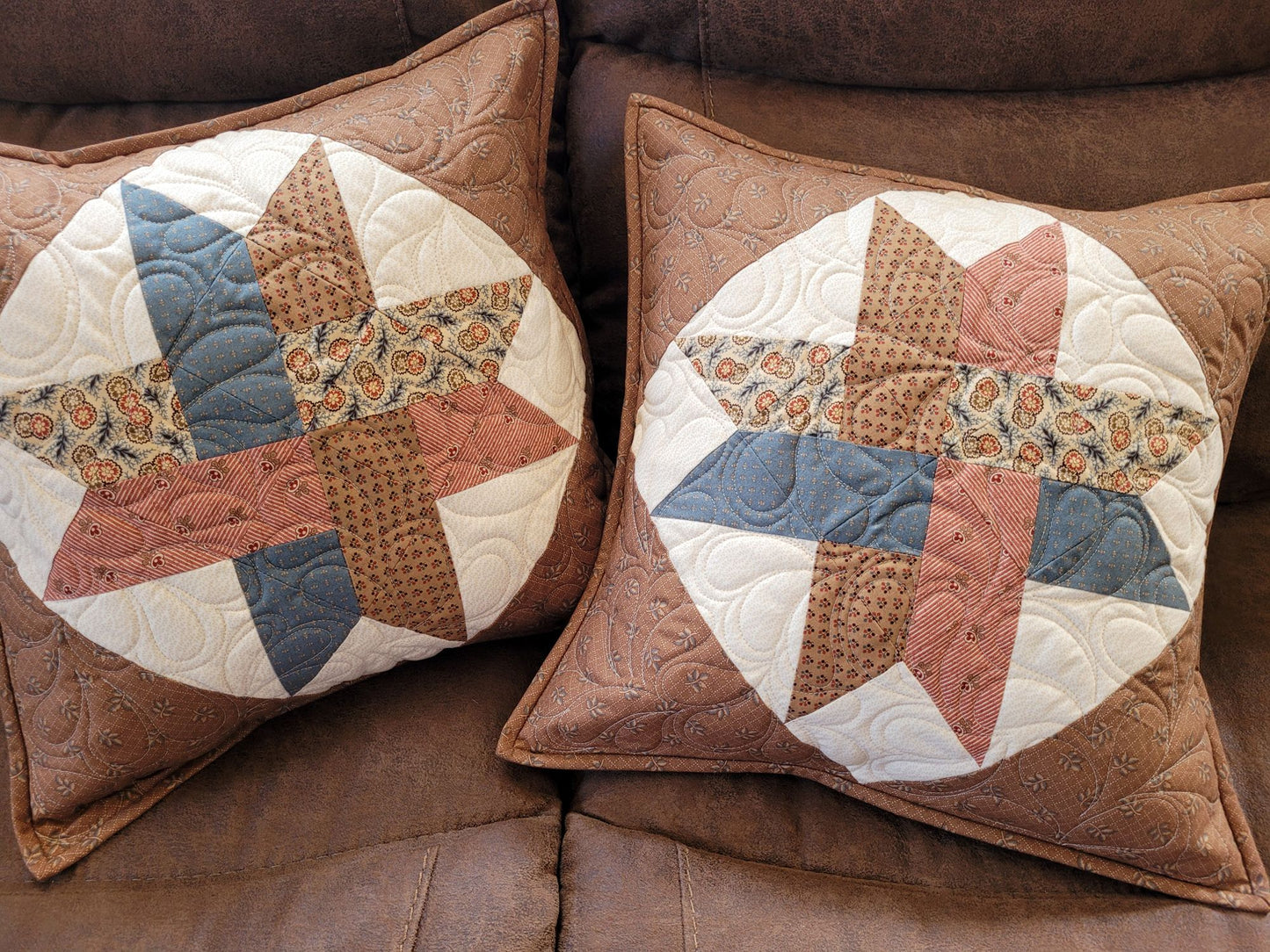 Two Woven Star Quilted Pillows sitting on a couch.