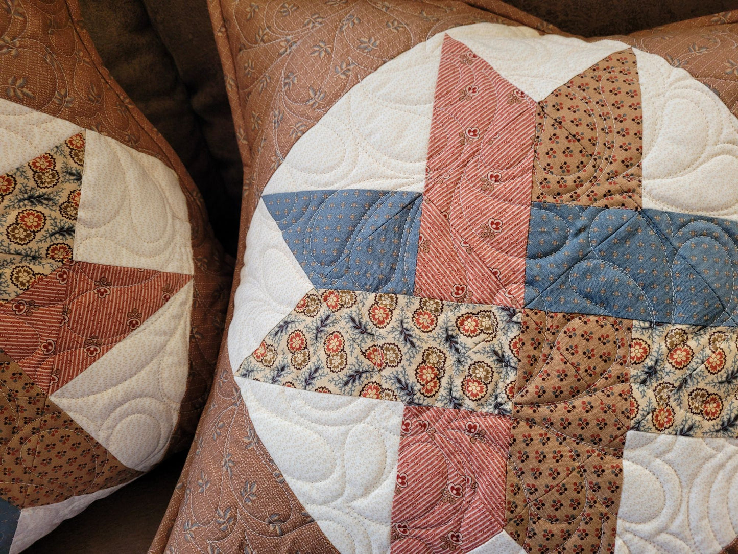 Close-up of a patchwork quilted pillow in a woven star pattern.