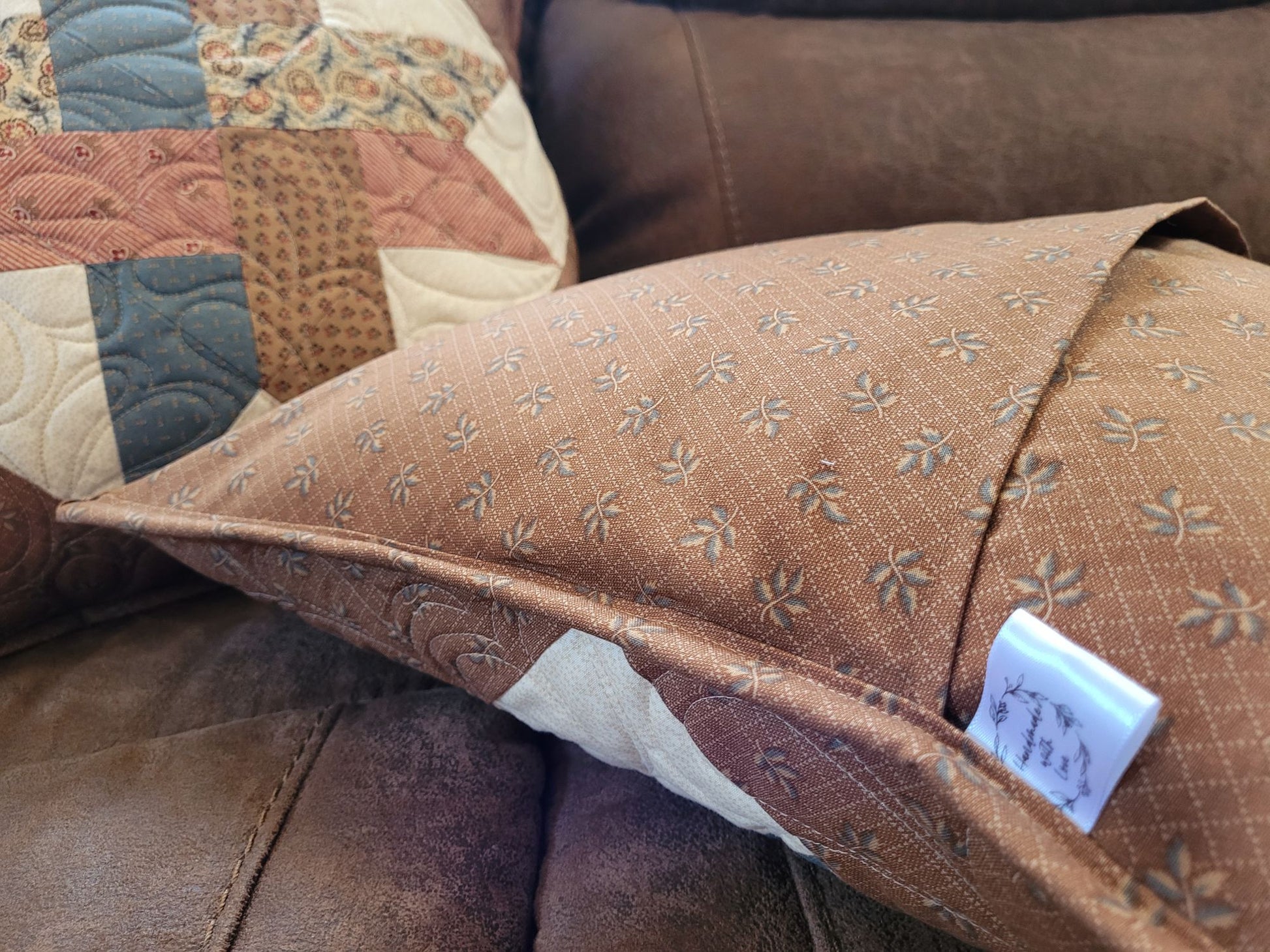 Showing overlapping back of the quilted pillows, sitting on a sofa.