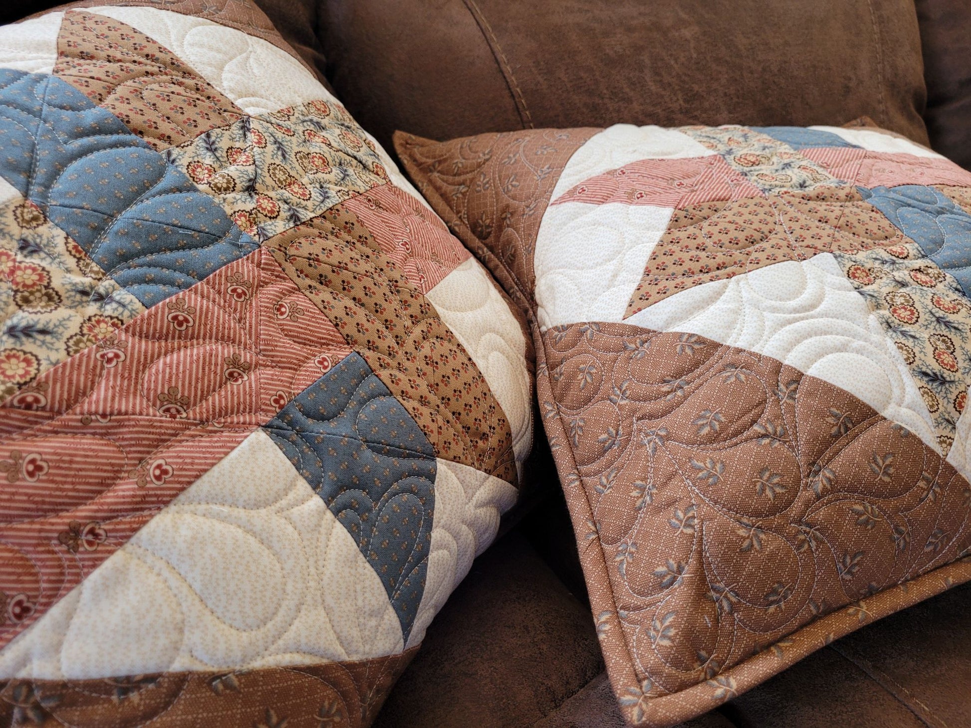 Patchwork quilted pillows on a brown sofa