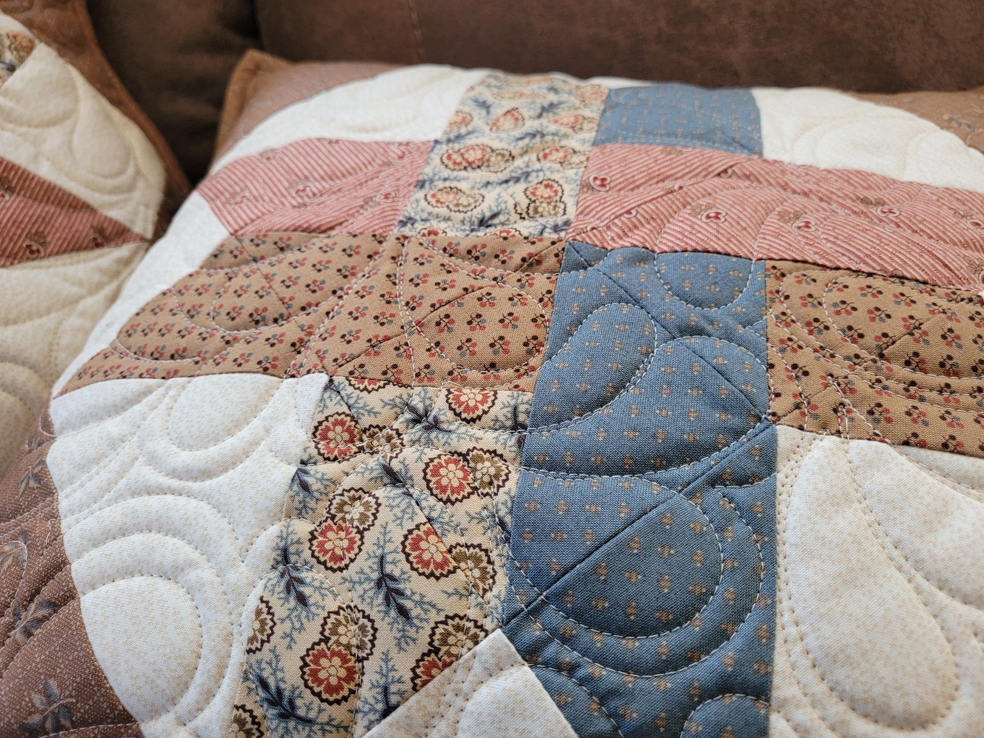 Close-up angle view of a patchwork quilted pillow done in civil war reproduction fabrics.