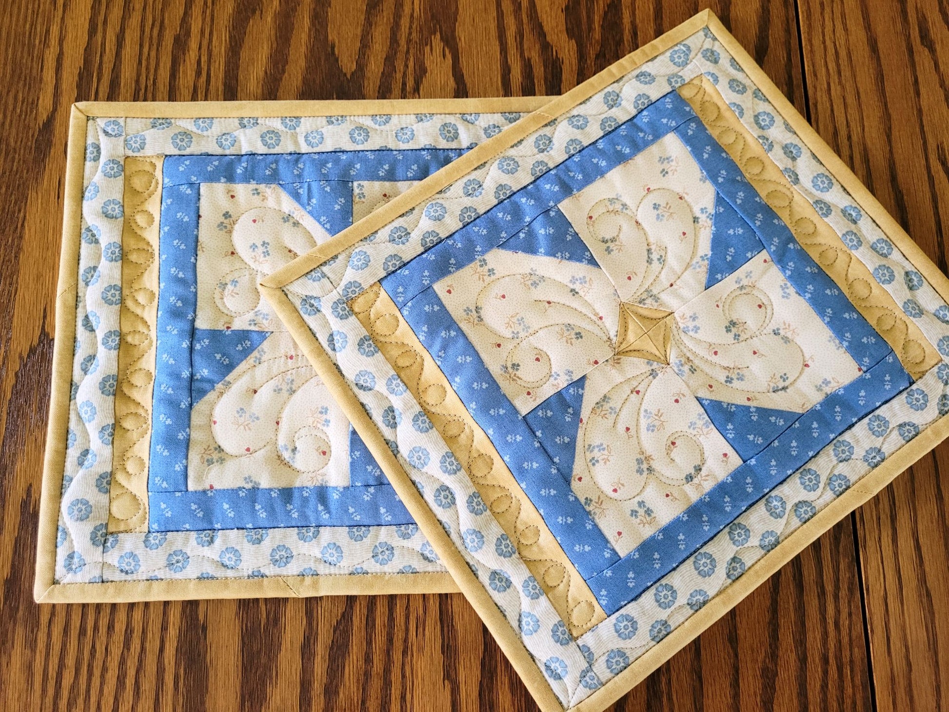 Two quilted hot mats in patchwork flower pattern.