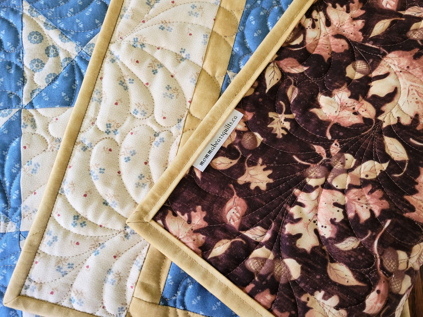 Quilted placemats showing the back which makes them reversible.