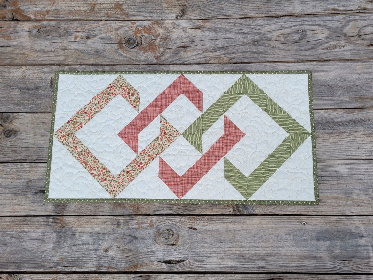Quilt with geometric pattern on a wooden surface