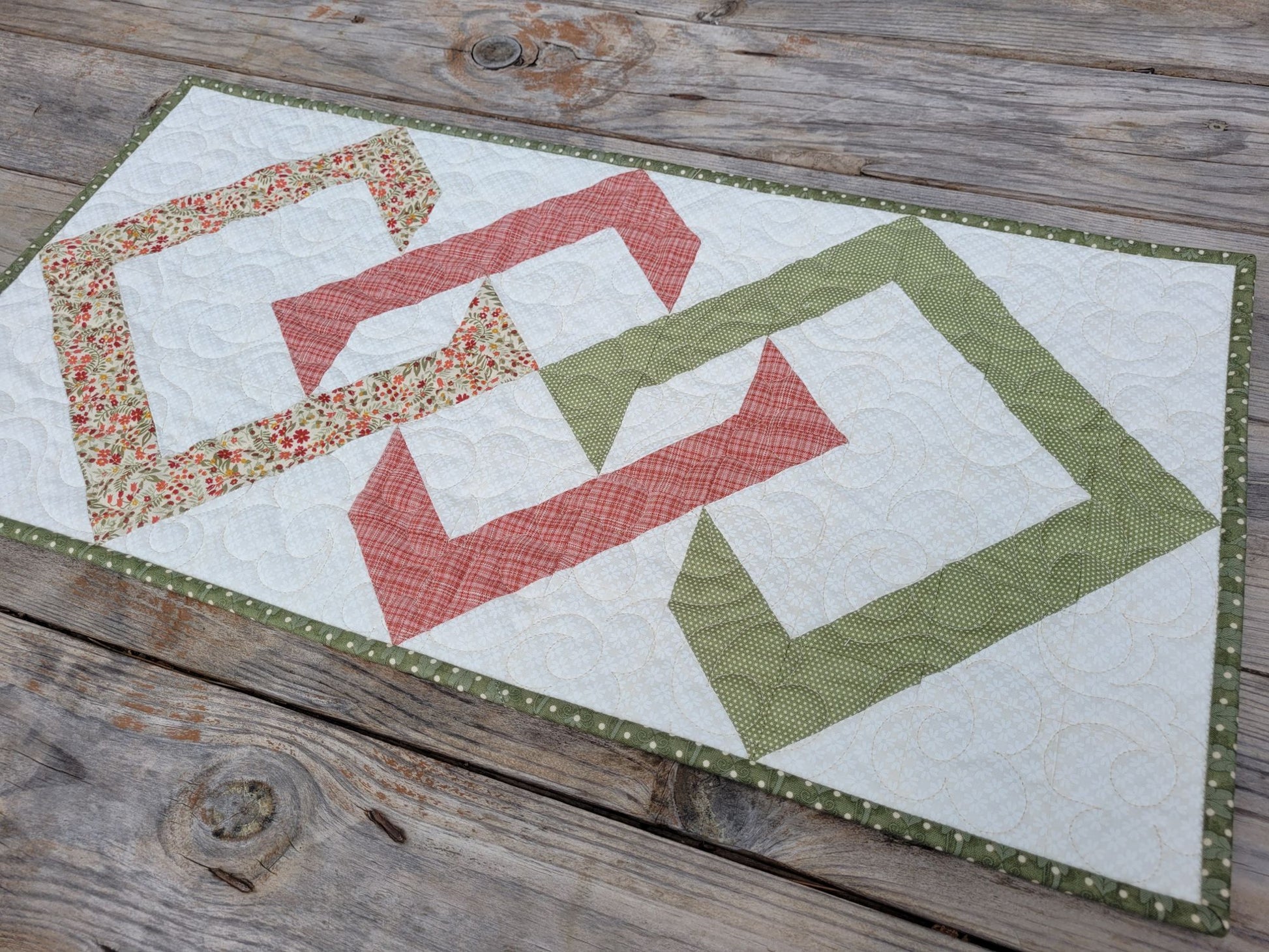 Quilted table runner with geometric pattern on a wooden surface