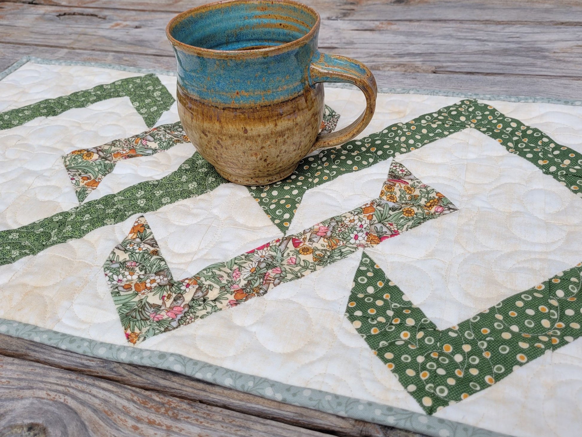 Ceramic mug on a quilted table runner with geometric patterns