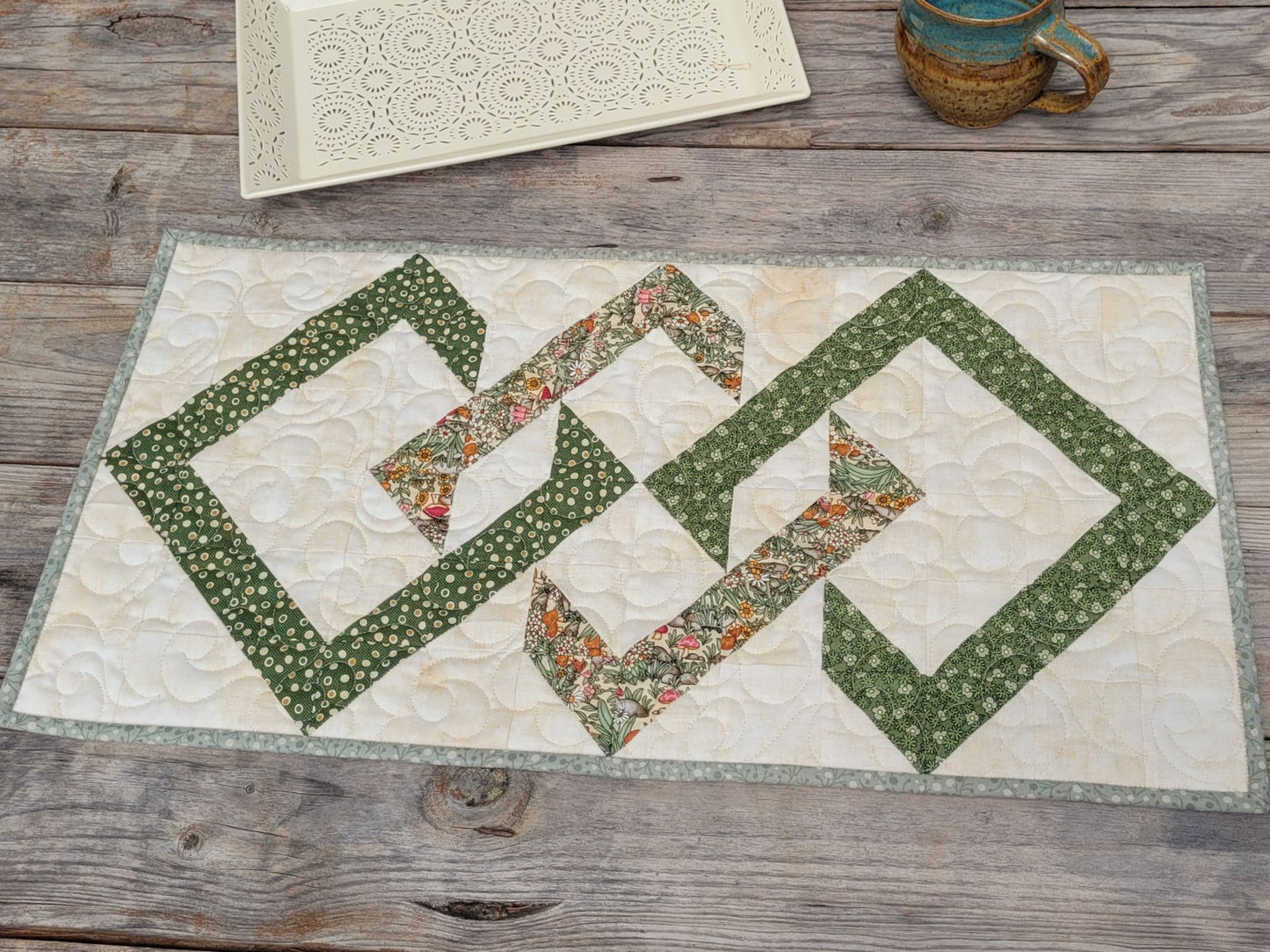 Quilted table runner with geometric pattern on a wooden surface