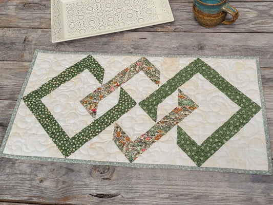 Quilted table runner with geometric pattern on a wooden surface