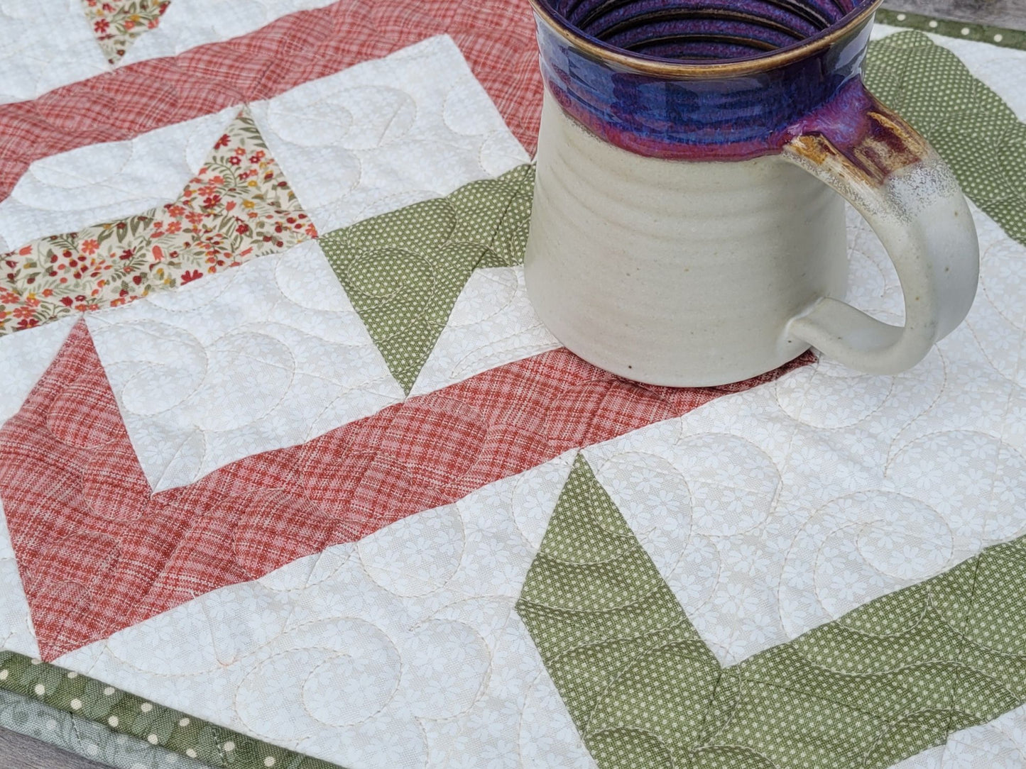 Pottery mug on a quilted table runner with geometric pattern