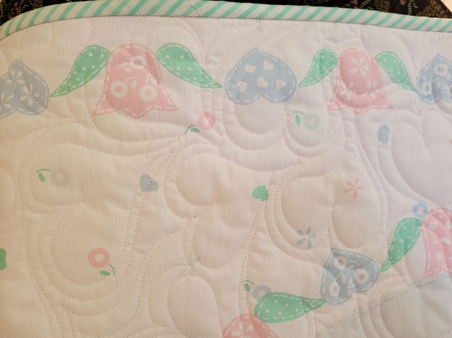 Close up of the quilt showing the heart and tulip borders and the striped binding