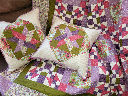 Patchwork Throw quilt with two matching pillows draped on a brown sofa. 