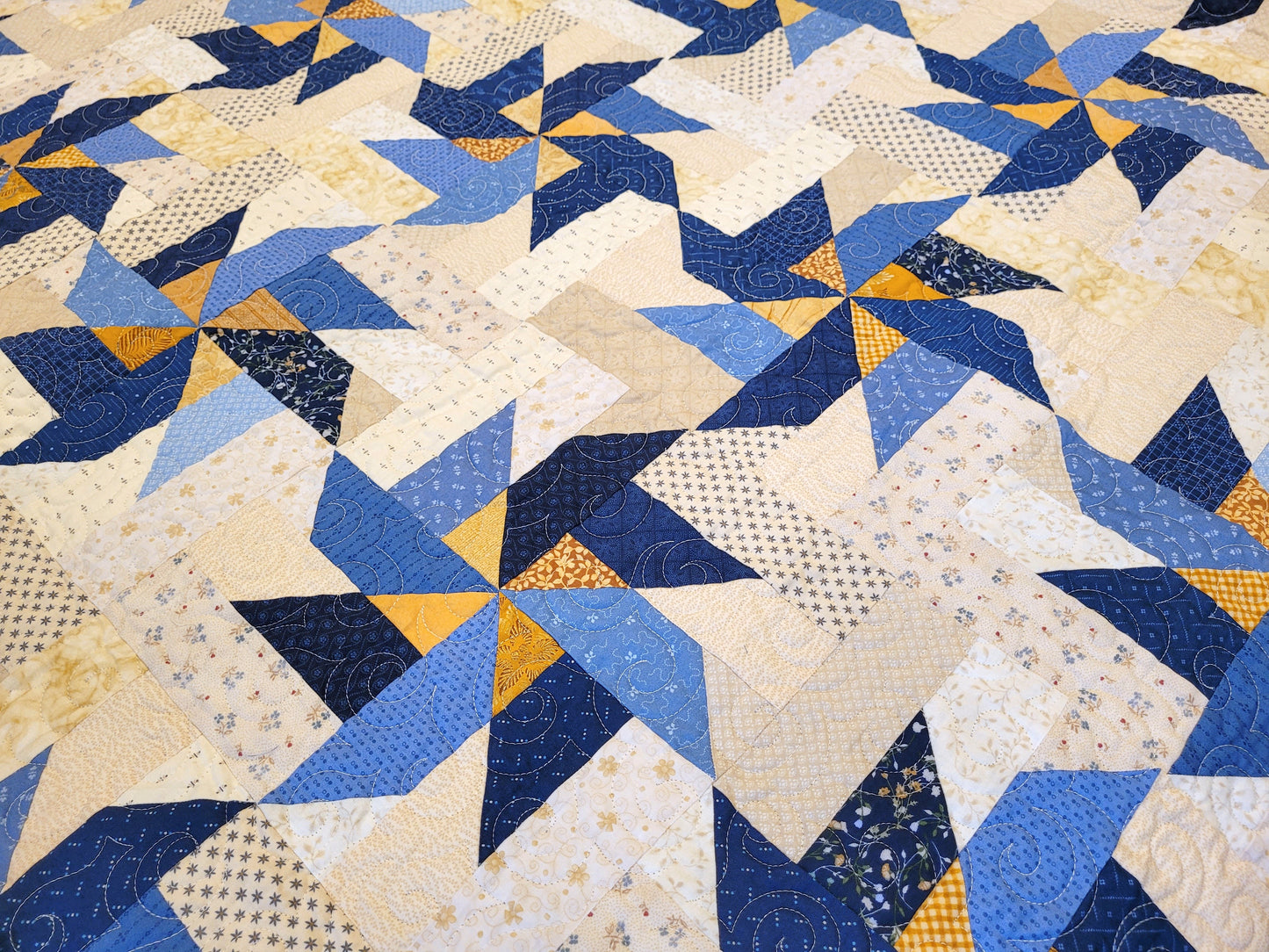 blue and gold pinwheels on king quilt
