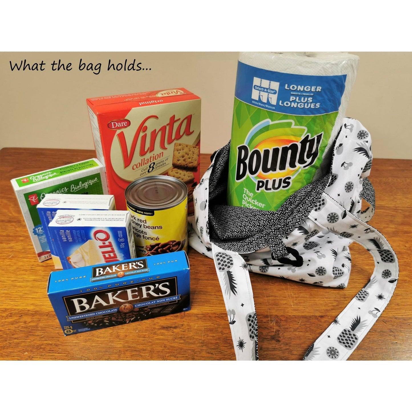 Image shows that the bag holds the following grocery items: Large roll Bounty paper towels, box Vinta crackers, can of kidney beans, two boxes of Jello pudding mix, small box fruit snack bars, box of Bakers unsweetened chocolate squares.