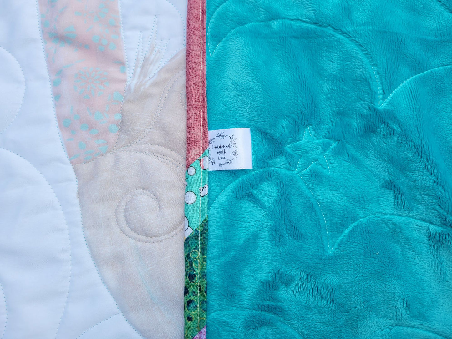 Showing baby quilt back and handmade label.