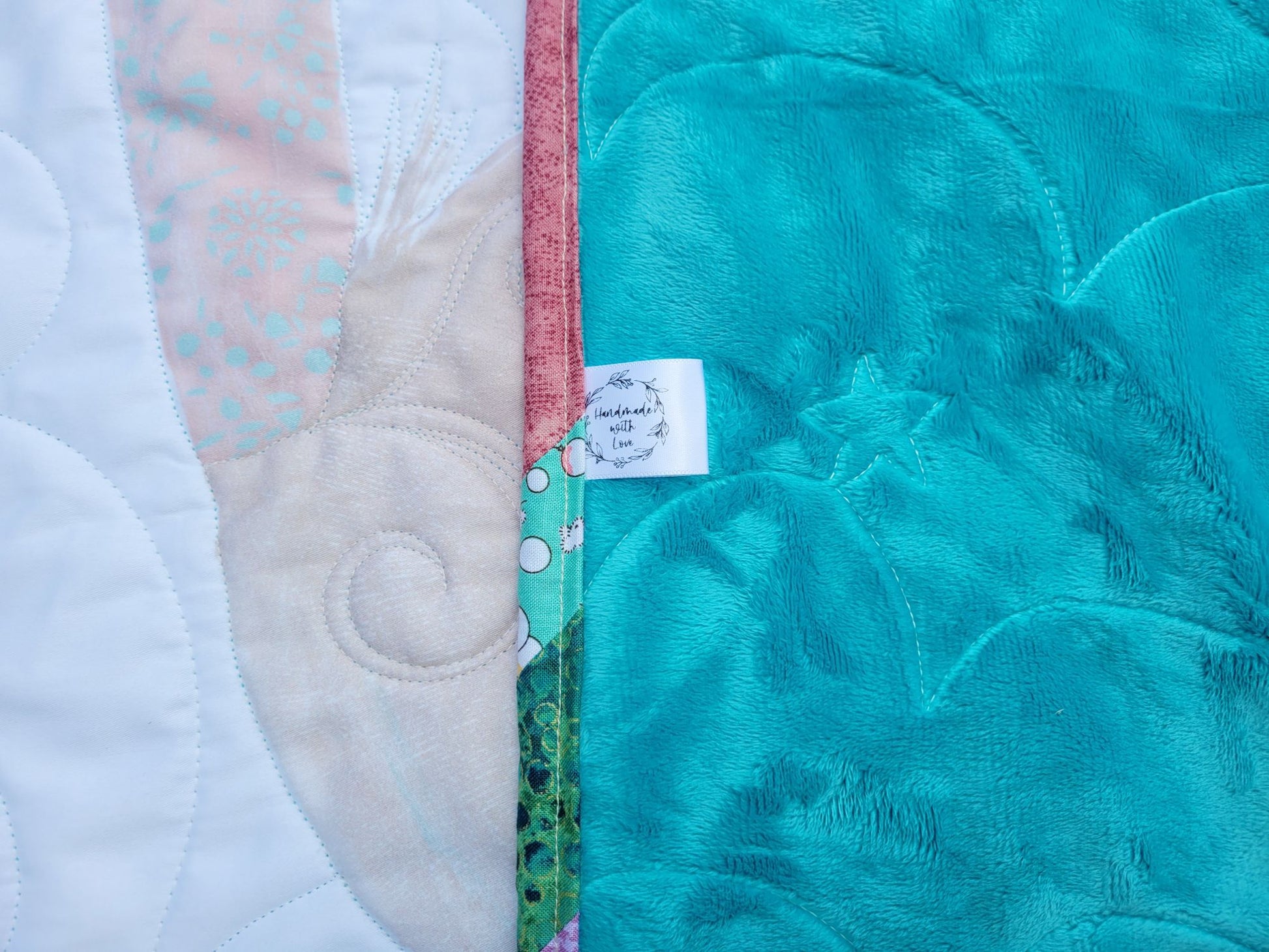 Showing baby quilt back and handmade label.