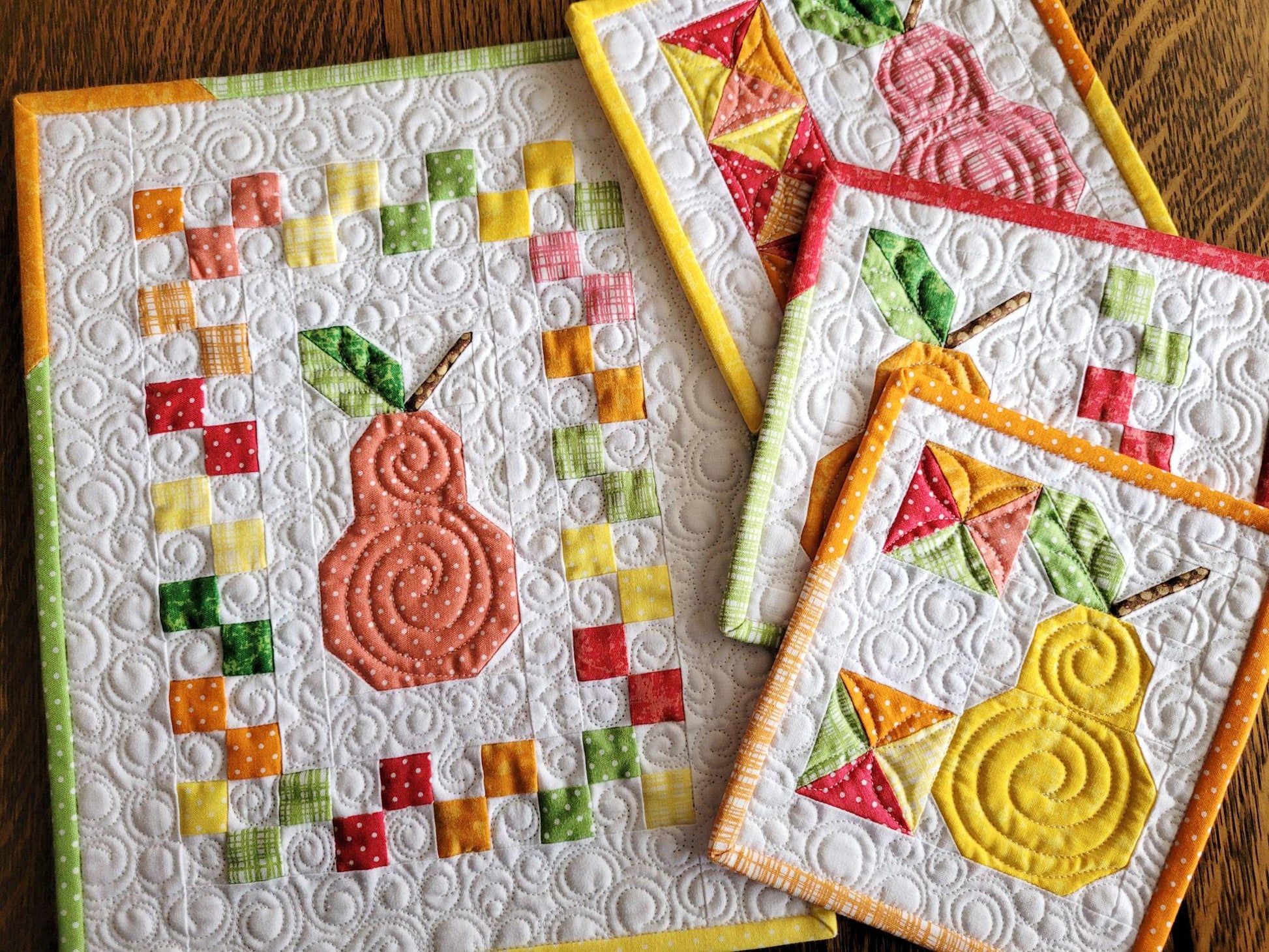 mini wall quilts in colorful scrappy patchwork pear fruit, showing quilting texture