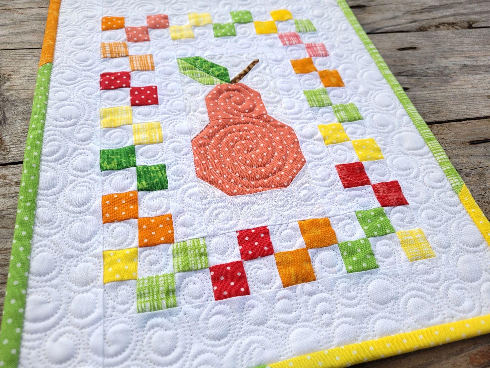 mini quilt with tiny patchwork and large pear fruit in center