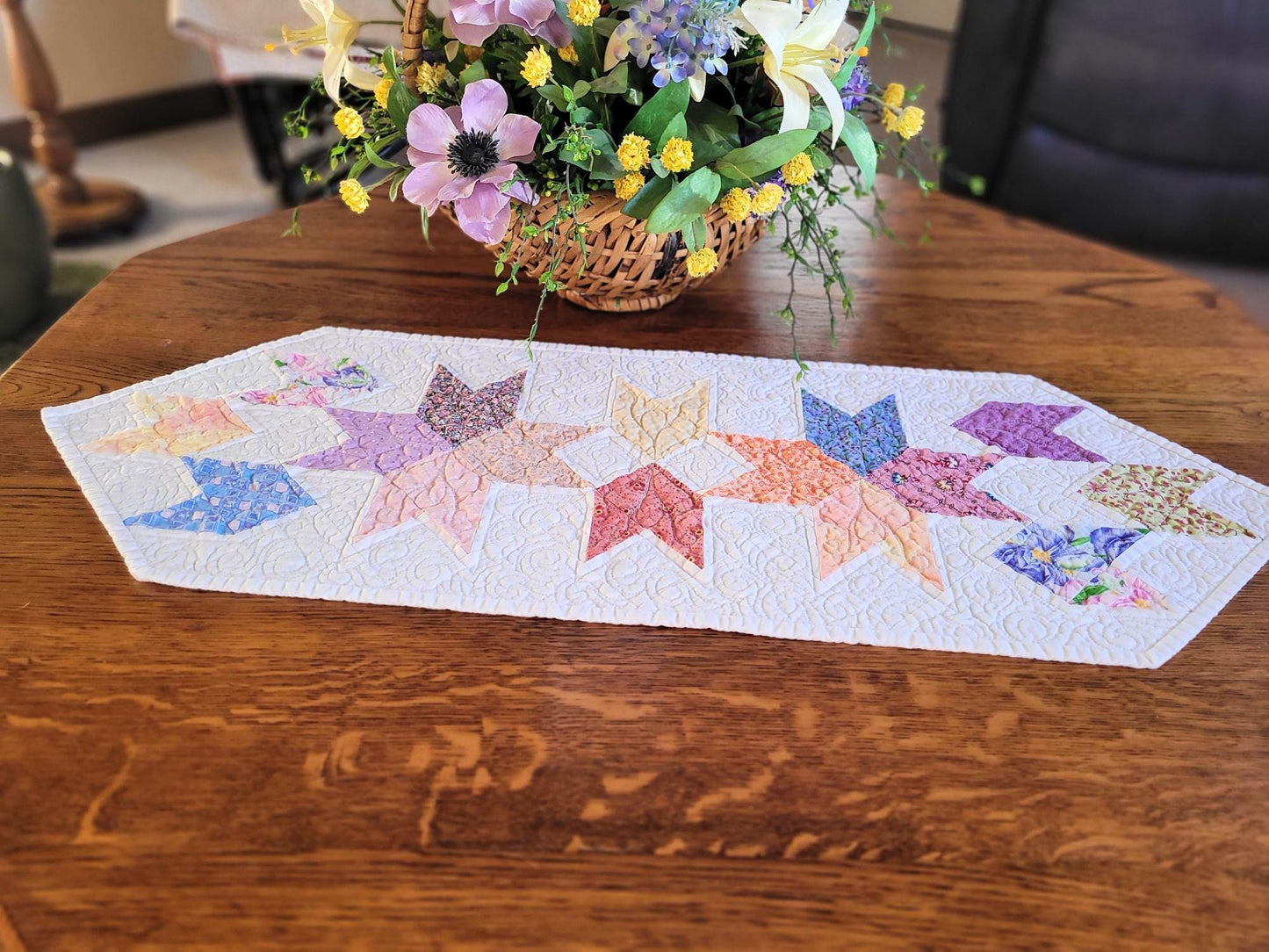 Spring table runner with pastel patchwork "tulips", on a wood table with flower basket, in a living room.