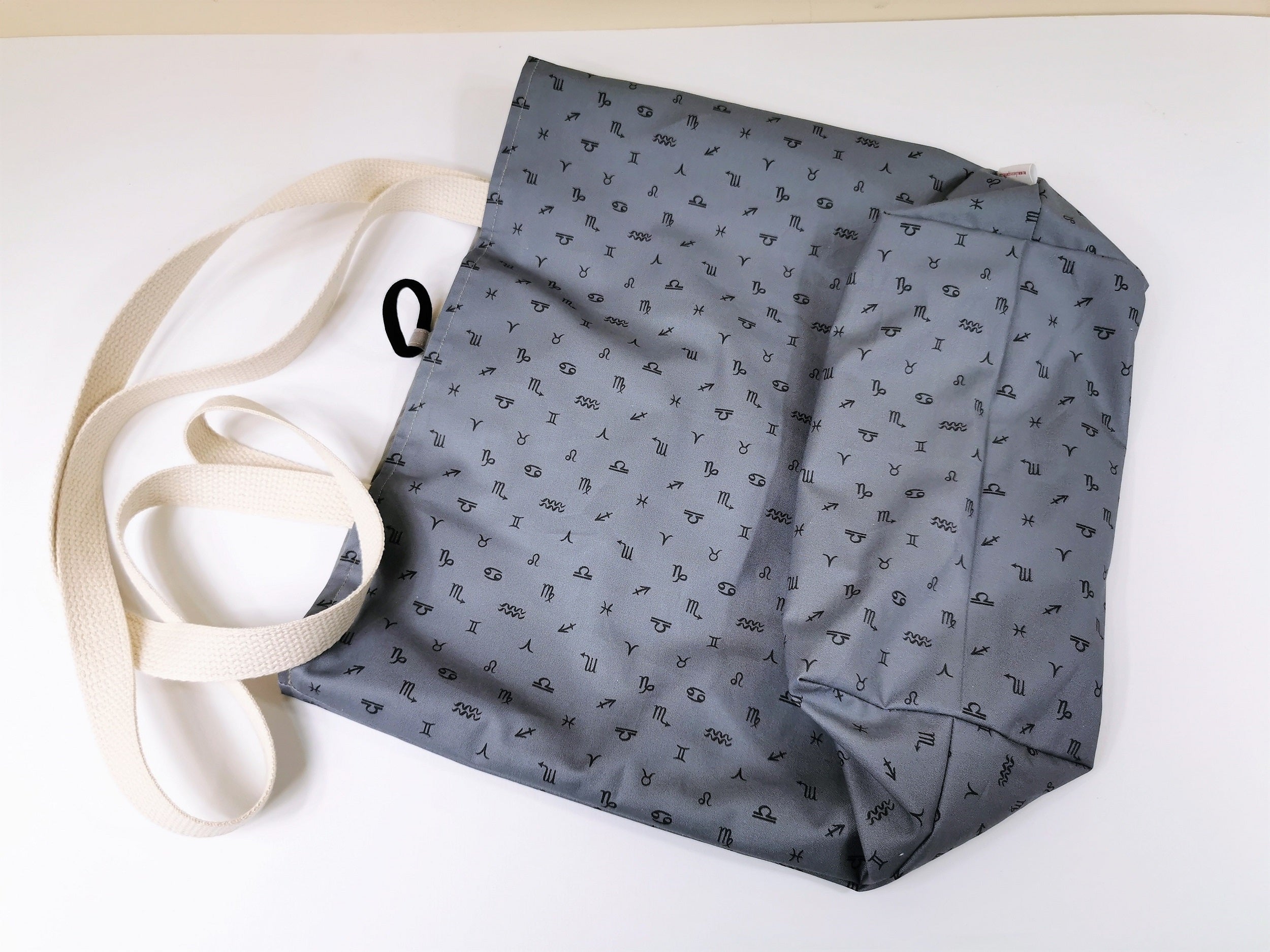 This horoscope tote bag is done in steel blue cotton fabric that has zodiac signs scattered throughout.  A basic tote bag that is ideal as large reusable shopping bag for your purse. 