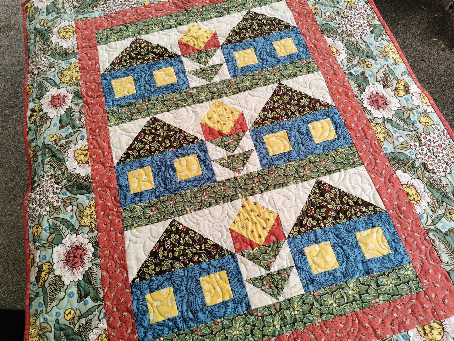 a large wall quilt with patchwork houses and flowers