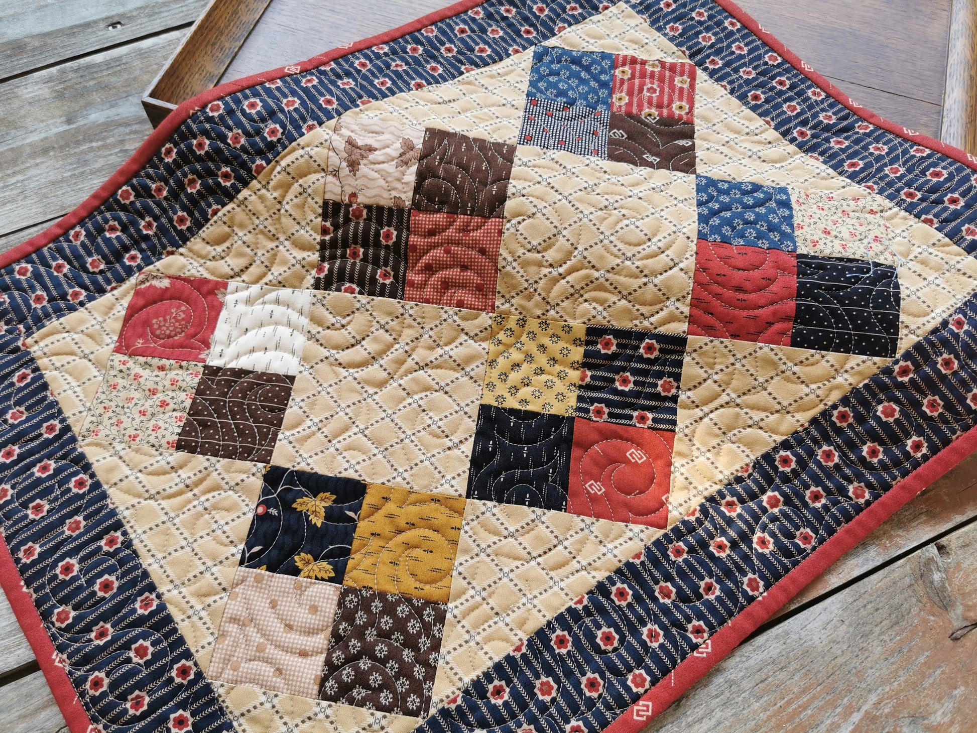 The quilted table runner is pictured on a slight angle to showcase the swirl quilting , which adds nice texture. Scrappy fabrics are civil war reproduction prints.