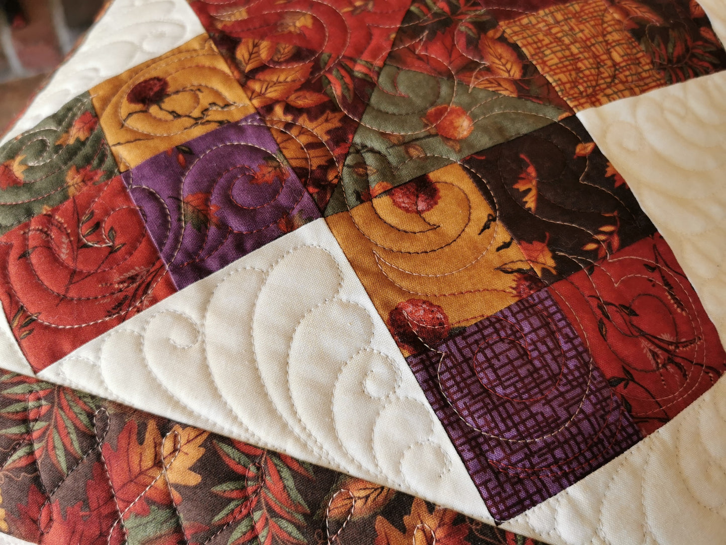 close up view of pillow showing beautiful quilting and lovely rich fall colours