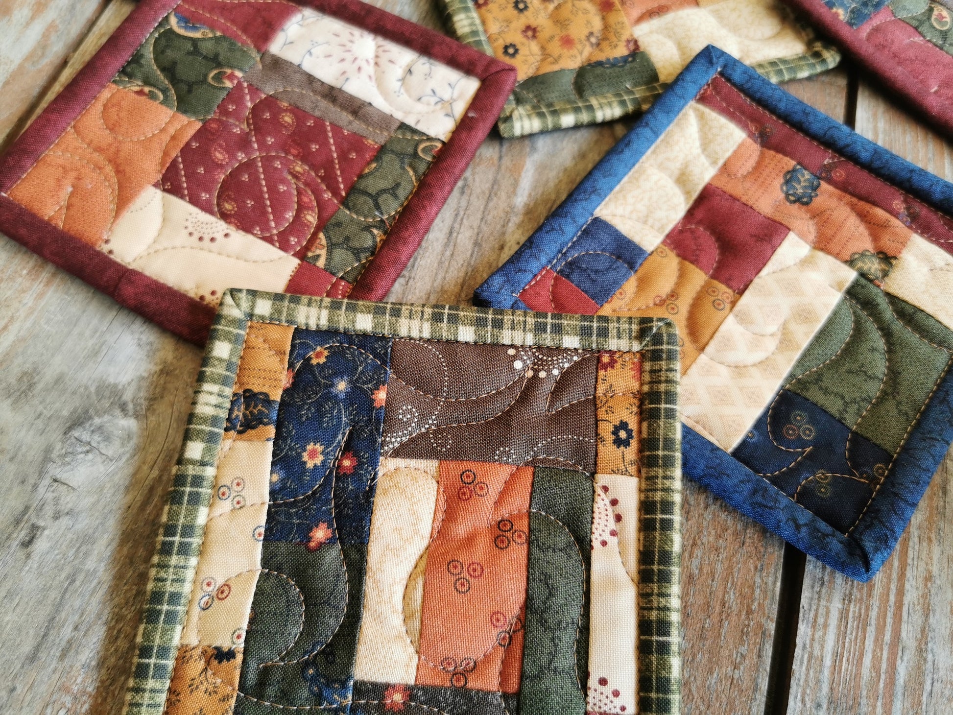 this close up shows the quilting texture and the scrappy patchwork of various coasters.