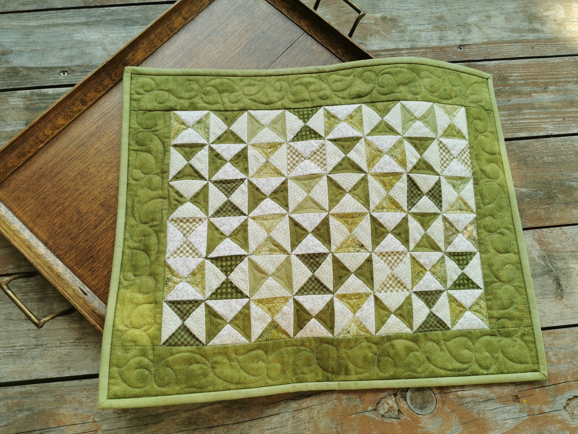 This green patchwork table runner has custom quilting and scrappy piecing to make a one of a kind quilt.