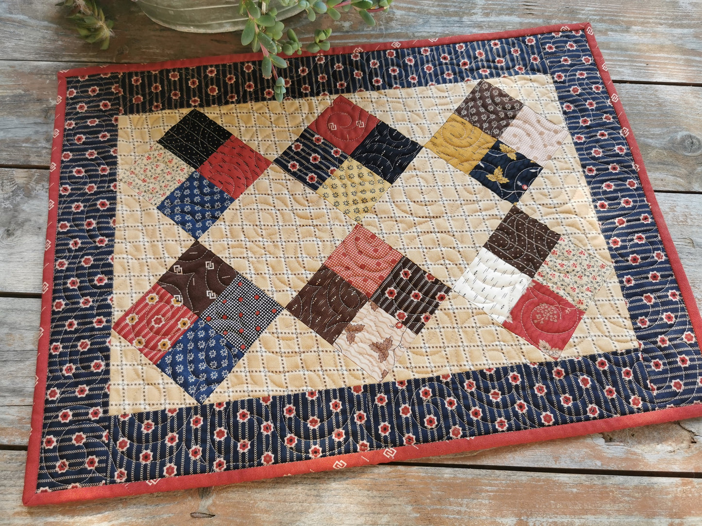 this small civil war scrap quilt is shown outdoors in natural light. A lovely rustic, vintage look using reproduction civil war fabrics.