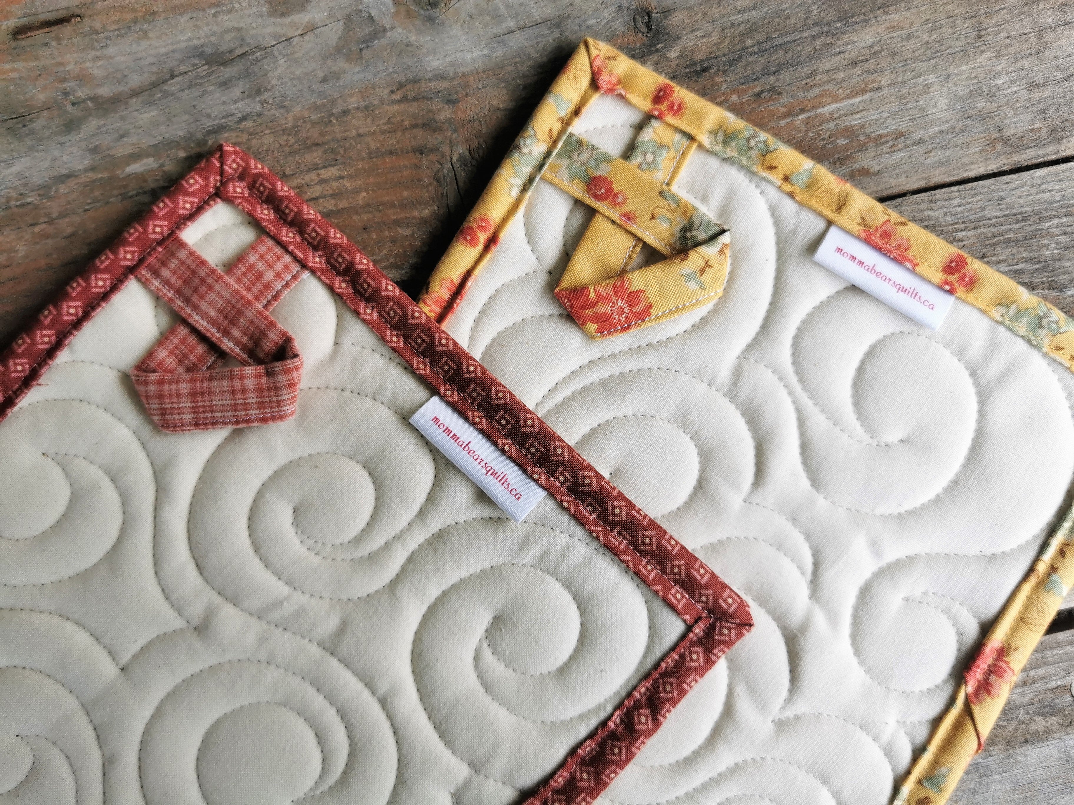 the back of the quilted patchwork potholders, showing the hanging loops and quilting