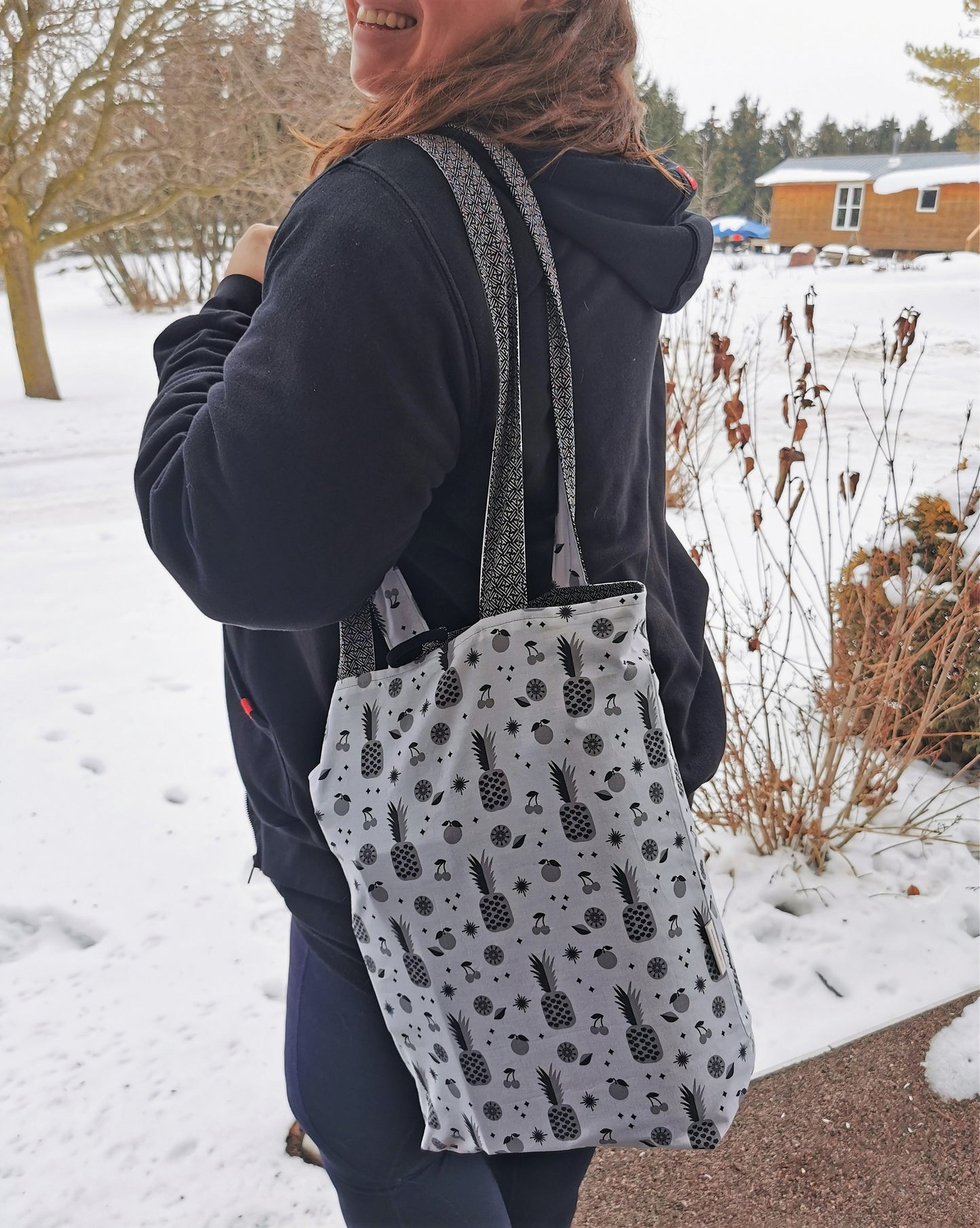 Image shows how the tote bag looks when hanging over a persons shoulder.