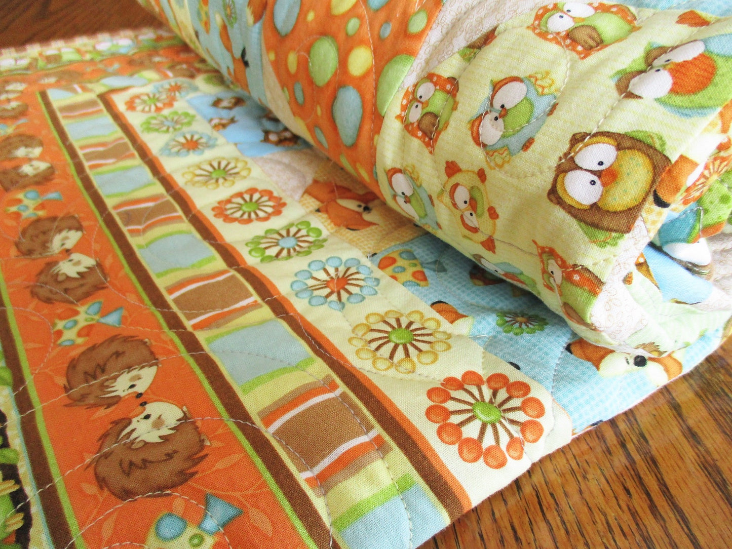 woodland animals adorn this sweet baby quilt. quality cotton fabrics, in gender neutral brown orange blue yellow green 