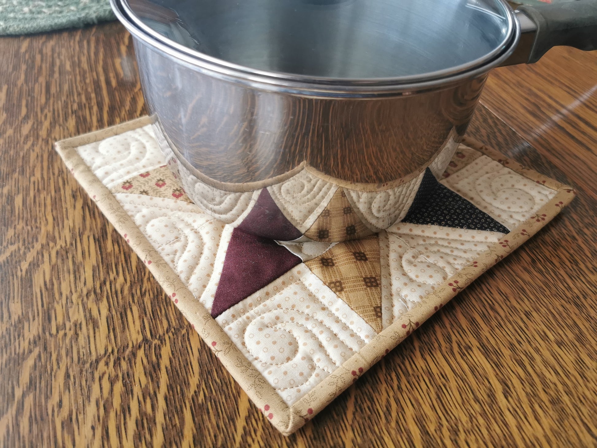 medium size saucepan sitting on star potholder