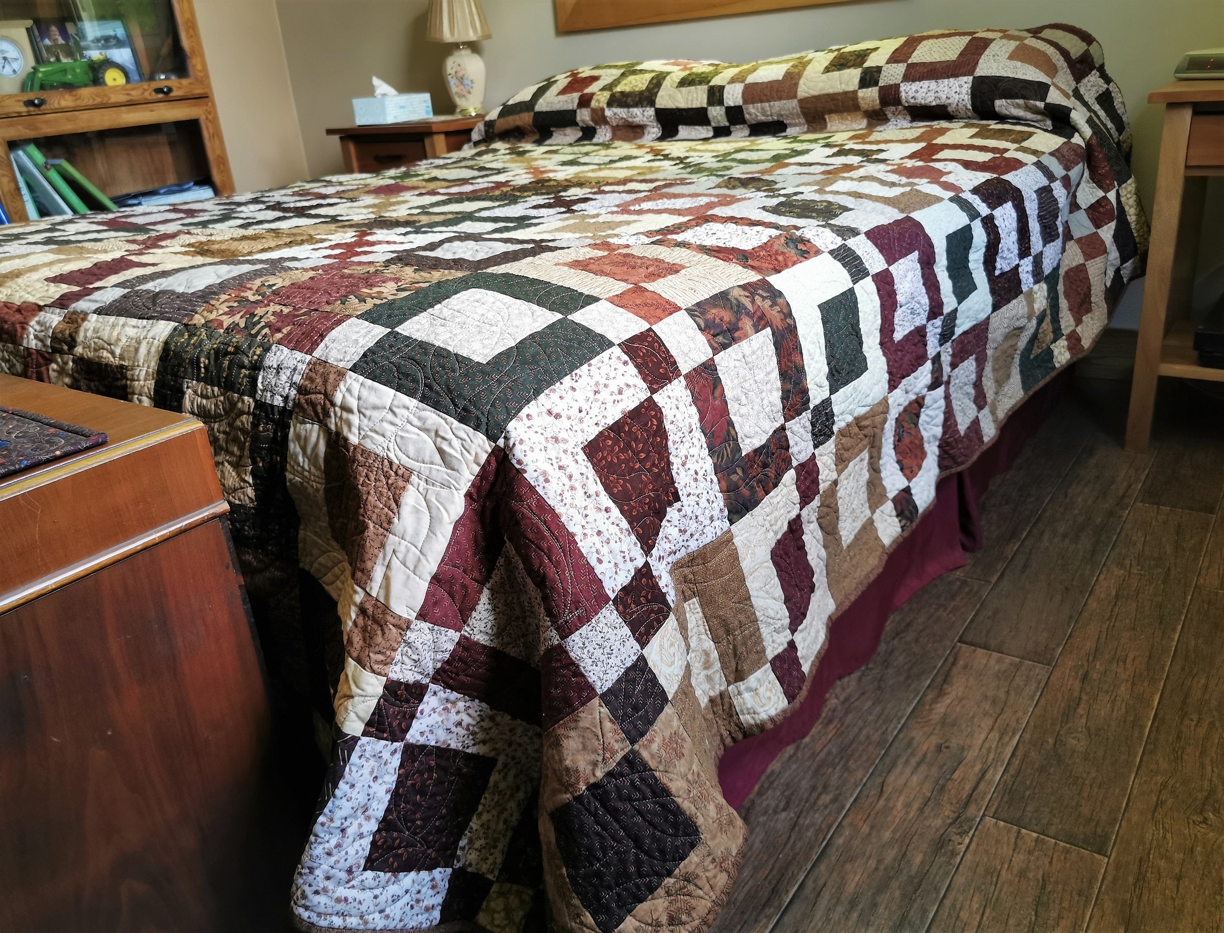 Quilt shown on queen bed, showing the drop on the sides and the quilt up over the pillows at the head of the bed.
