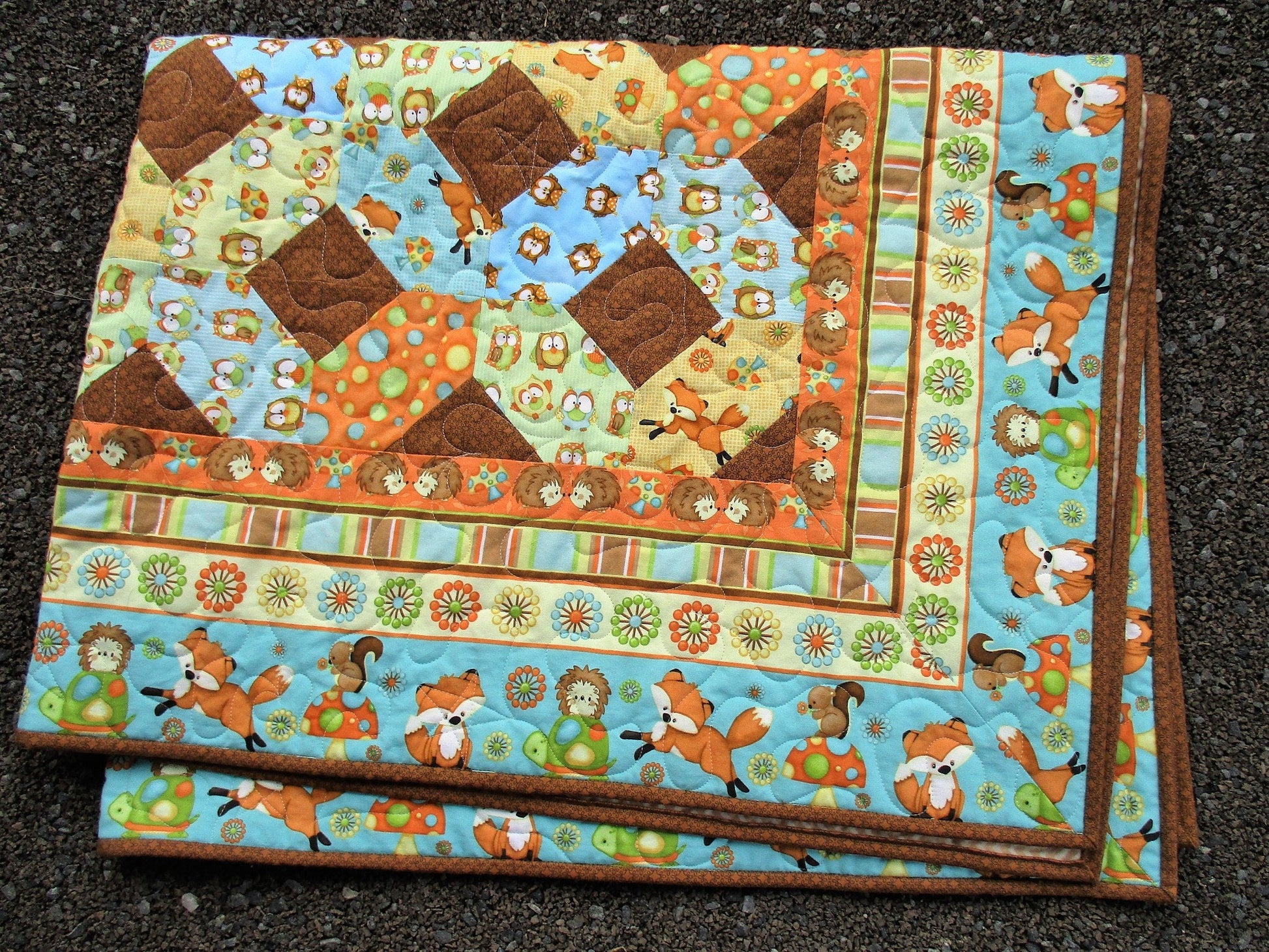 the folded quilt showing the mitred corners on the outer border which creates a nice framing effect.