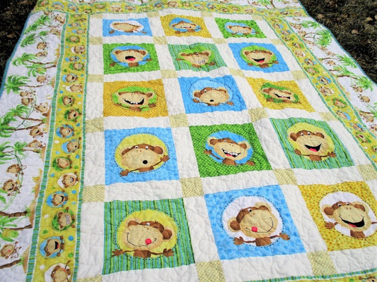 An angle view  of the funny face monkey quilt and jungle theme borders. 