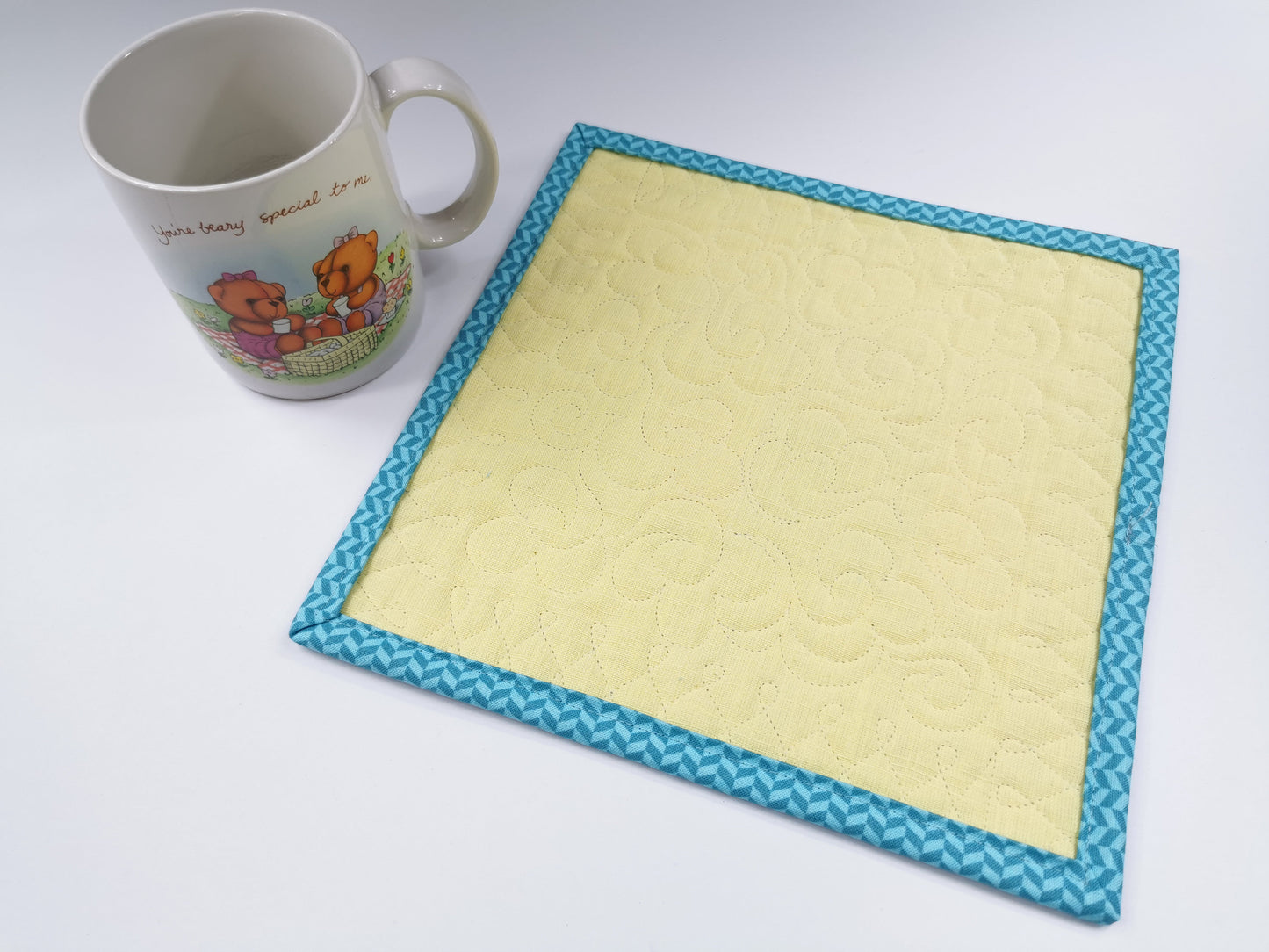 back view of mug rug with coffee mug sitting beside