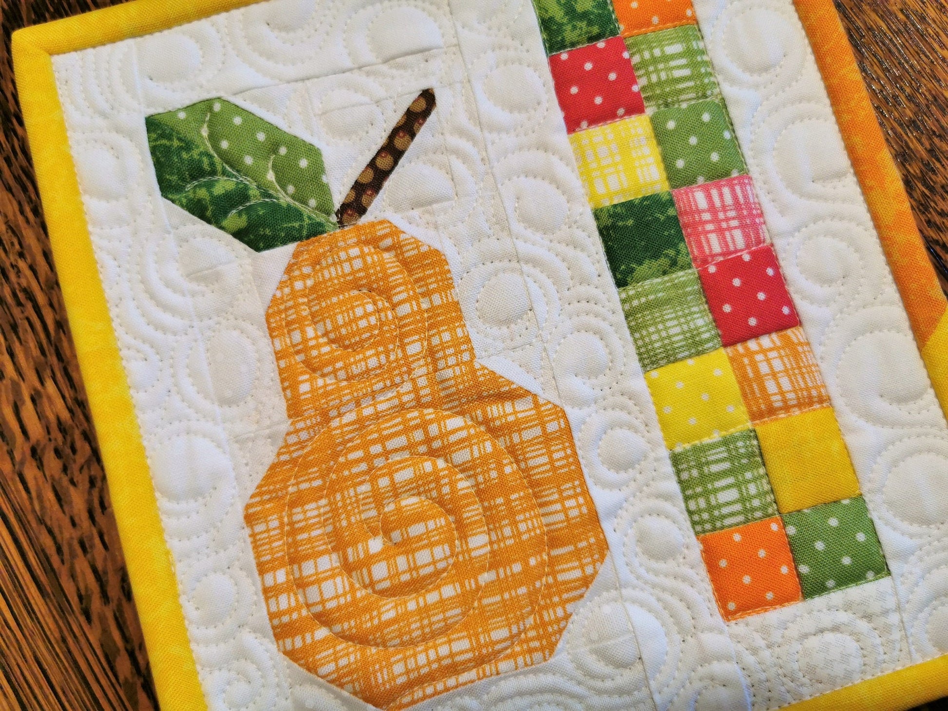 The tiny piecing in this patchwork pear and the custom quilting detail add up to an eye catching, one-of-a-kind charming little quilt. 