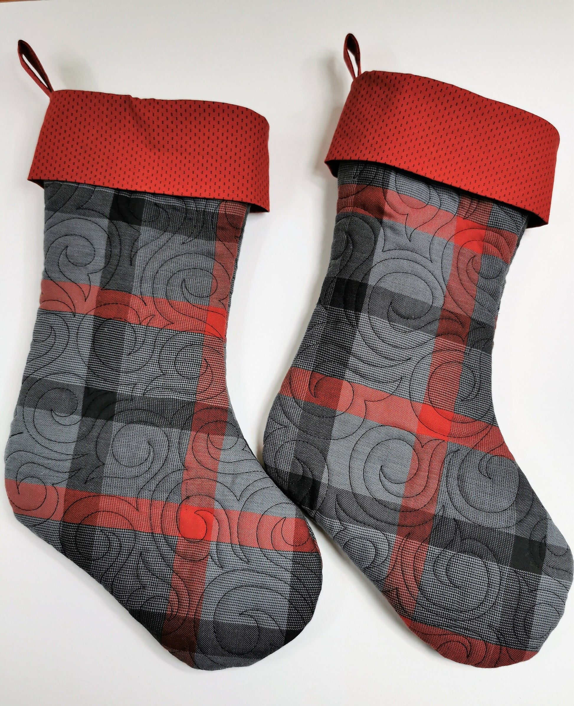 two quilted christmas stockings shown with toes pointing right
