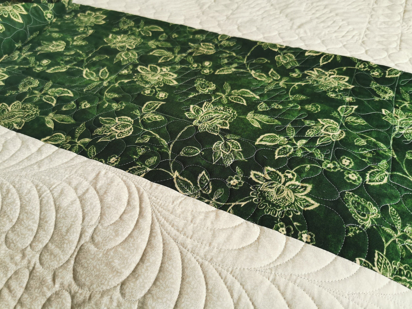 Showing the custom feather quilting and the dark green stripe on the back of the vintage queen quilt.