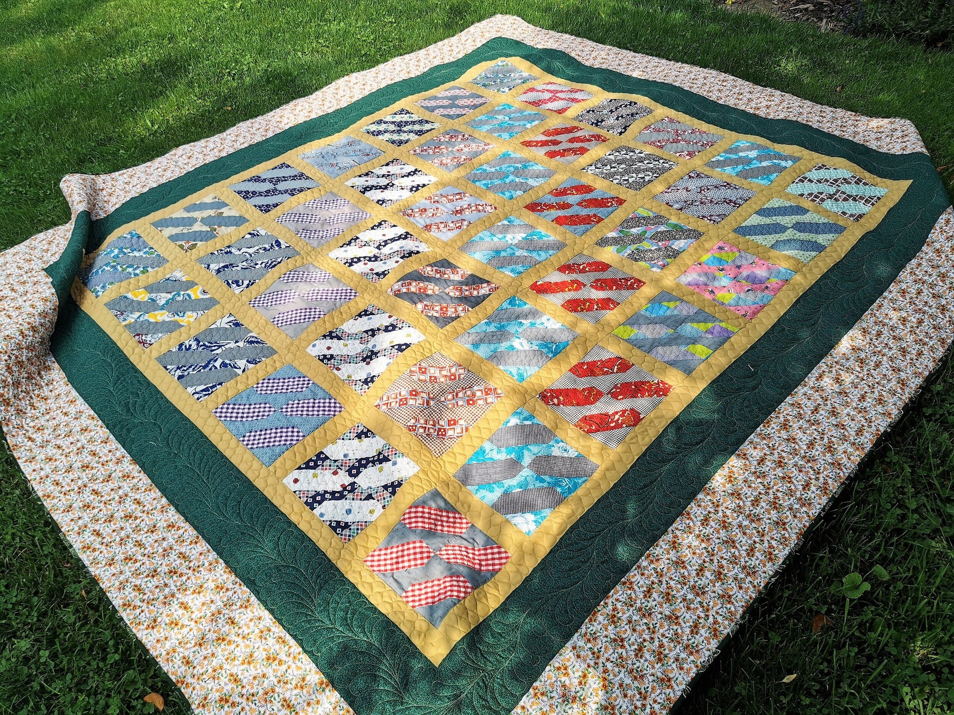 vintage queen quilt shown outdoors on the grass, in dappled shade