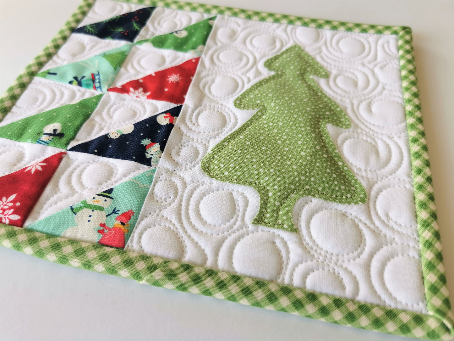 large quilted fabric coaster with evergreen tree and scrappy patchwork