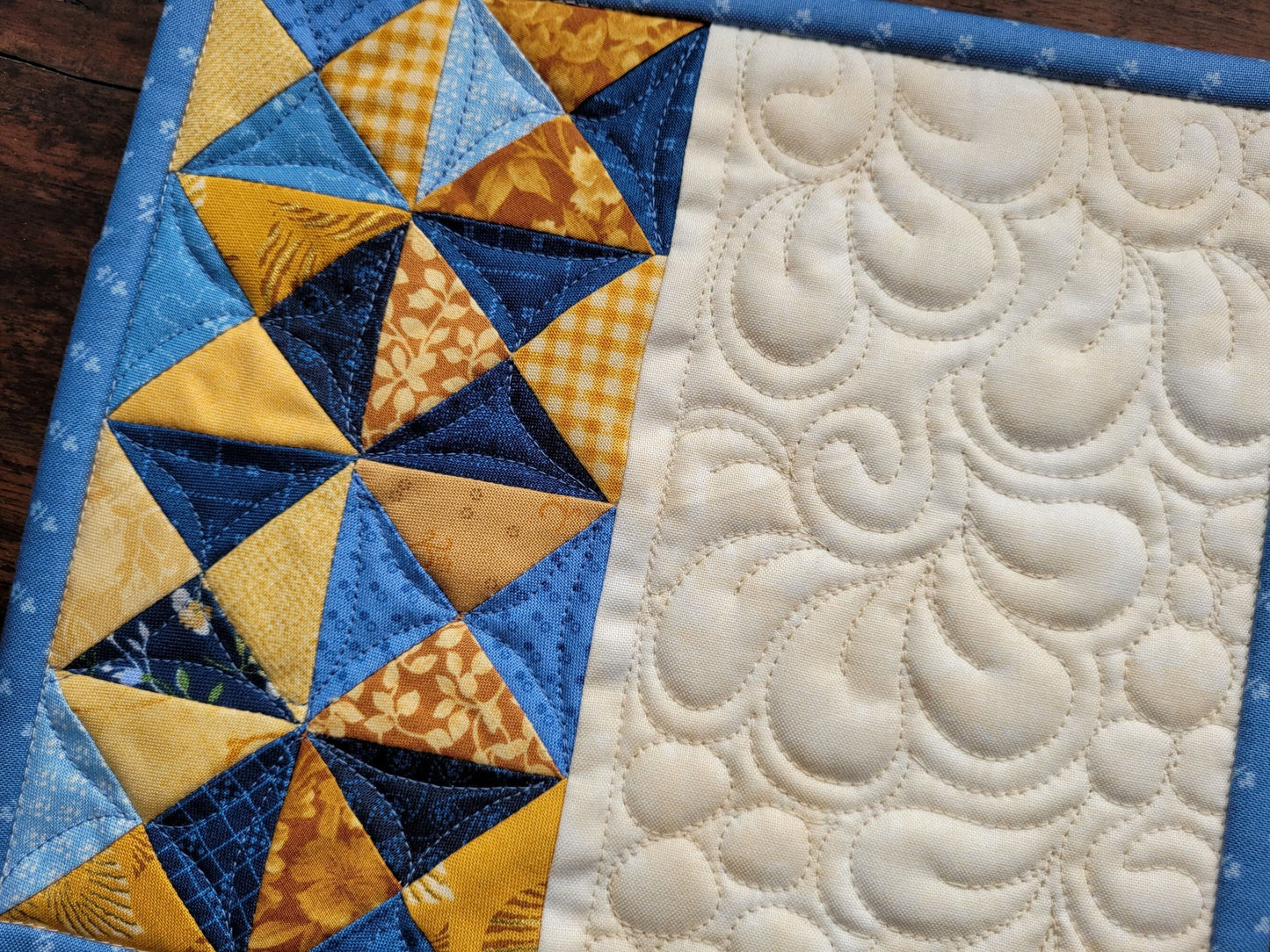 close up of blue and gold mini quilt mug rug