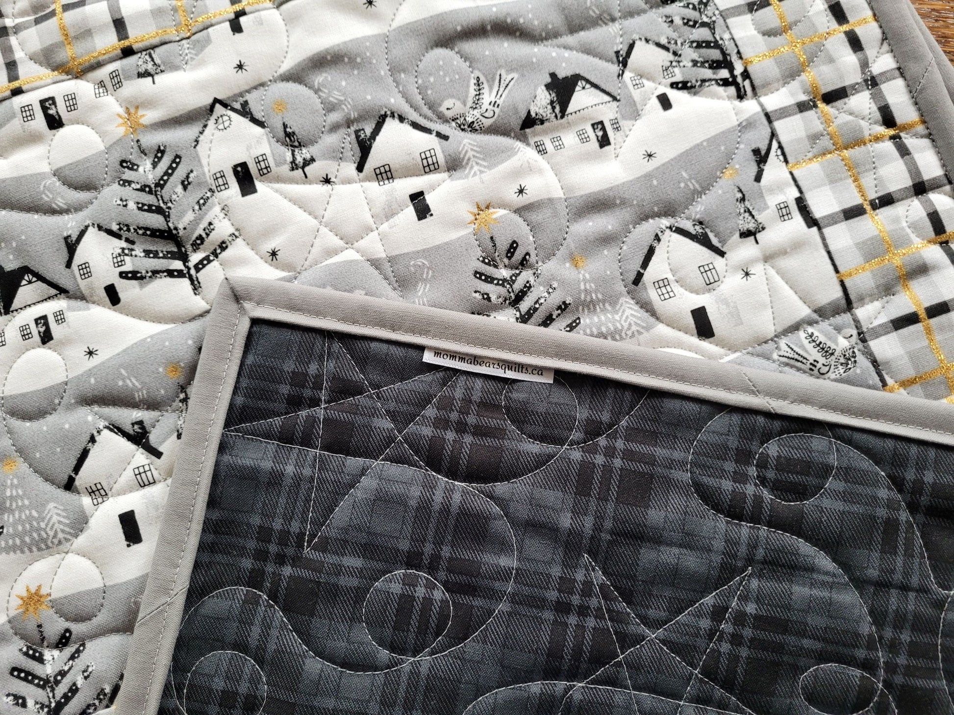 showing black plaid back of quilted placemats with stars and loops stitching