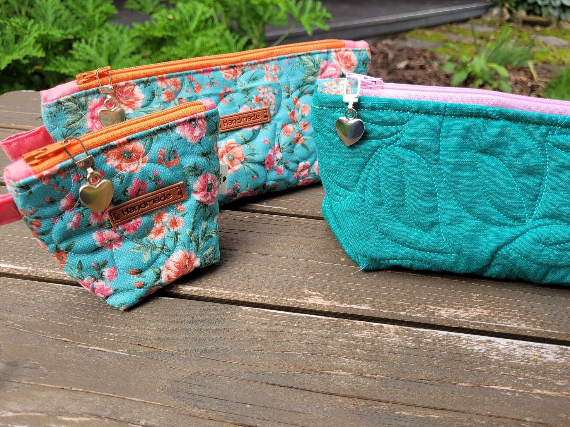 three quilted zipper pouches in coordinating fabrics